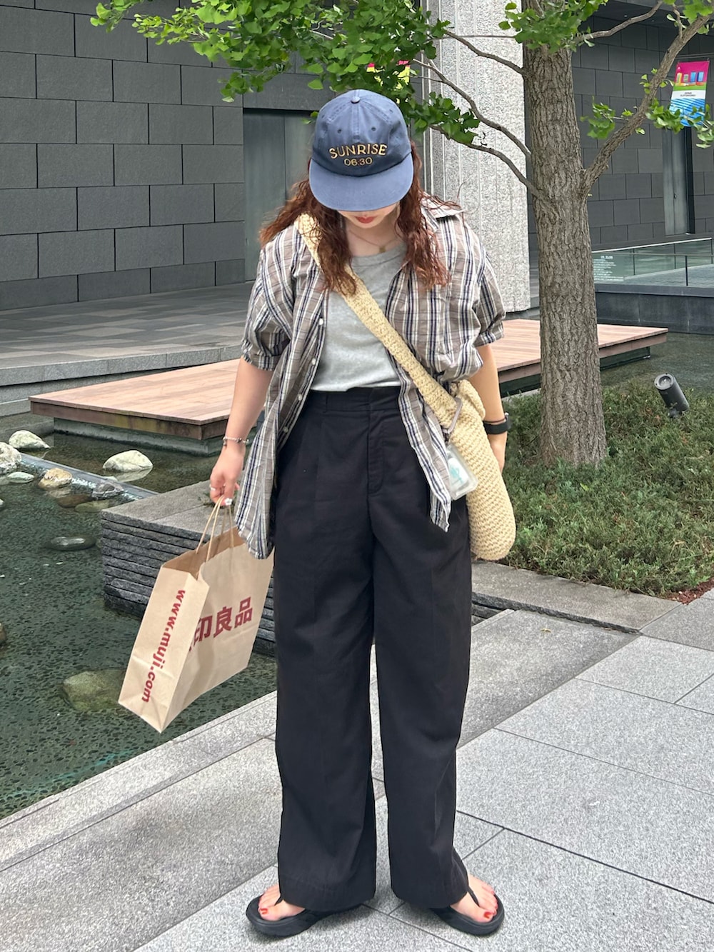 ベージュ系のショルダーバッグ、ブラウン系のシャツ/ブラウス、ブラック系のスラックスを着用したレディースの夏コーディネートの3枚目の写真