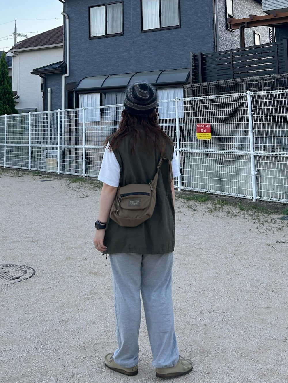 グリーン系のベスト、ホワイト系のTシャツ/カットソー、グレー系のスウェットパンツを着用したレディースの秋コーディネートの2枚目の写真