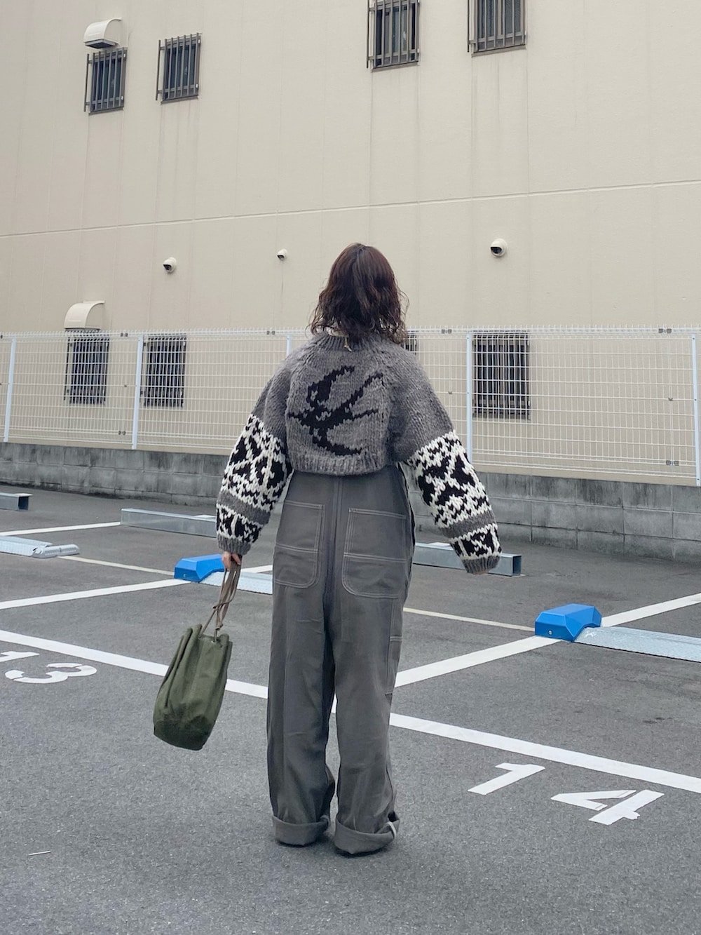 グリーン系のハンドバッグ、グレー系のサロペット/オーバーオール、ベージュ系のモカシン/デッキシューズを着用したレディースの冬コーディネートの3枚目の写真