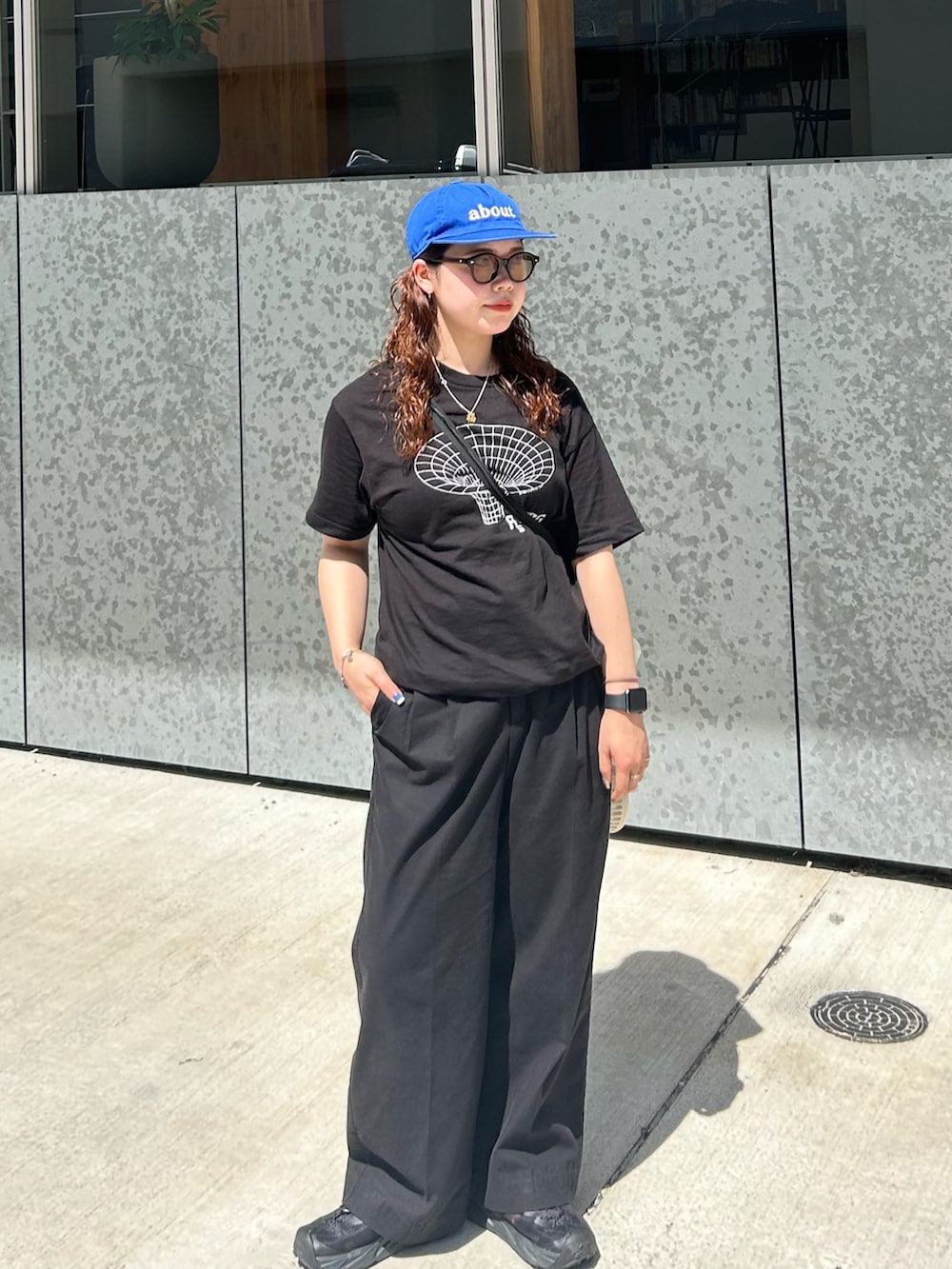 ブラック系のTシャツ/カットソー、ブラック系のスラックス、ブラック系のサンダルを着用したレディースの夏コーディネートの2枚目の写真