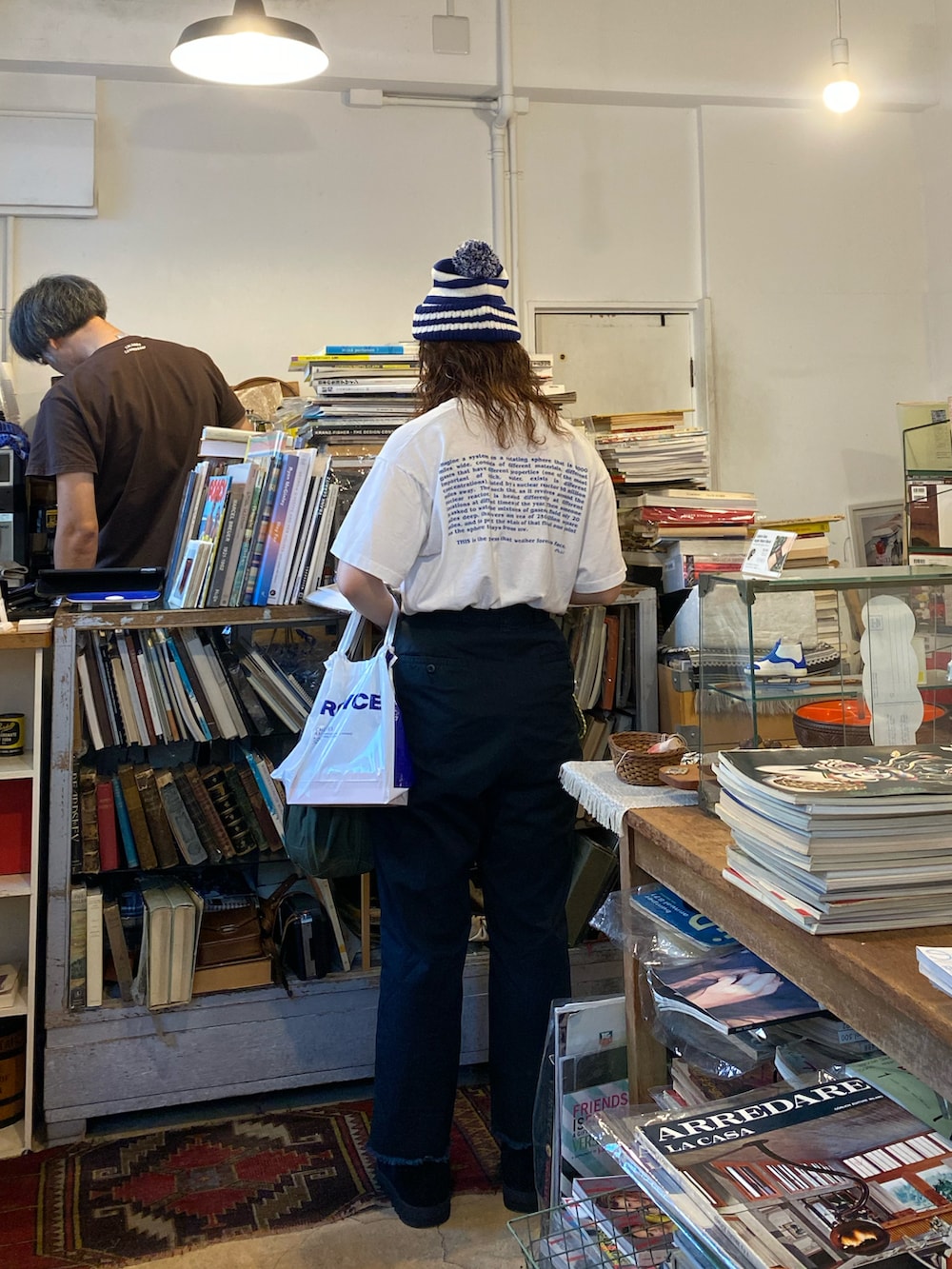 ブラック系のチノパンツ、グリーン系のハンドバッグ、ブラック系のスリッポンを着用したレディースの秋コーディネートの2枚目の写真