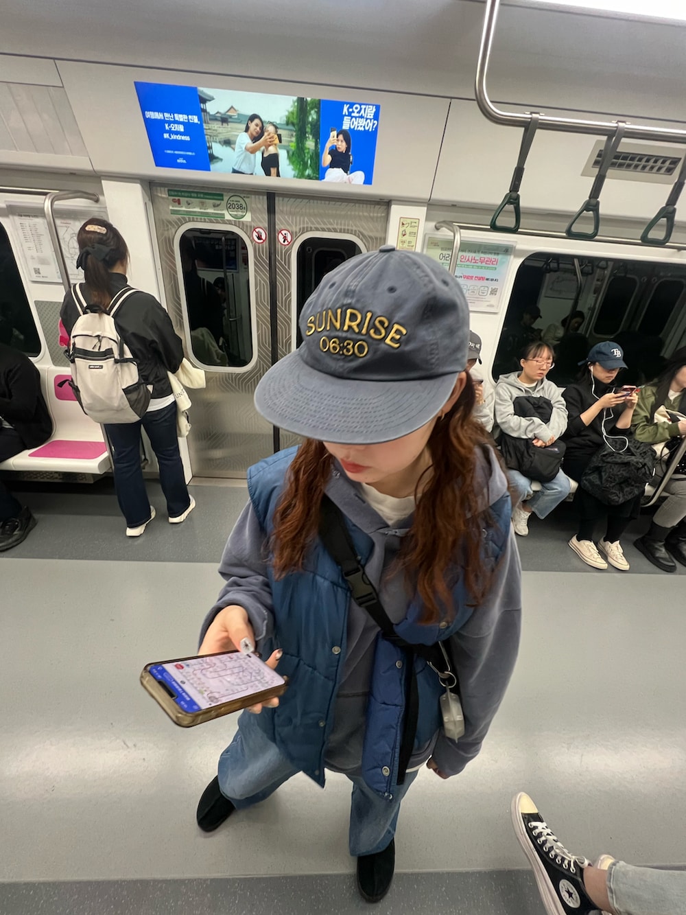 ブルー系のデニムパンツ、ブラック系のスリッポン、ブルー系のパーカーを着用したレディースの秋コーディネートの3枚目の写真