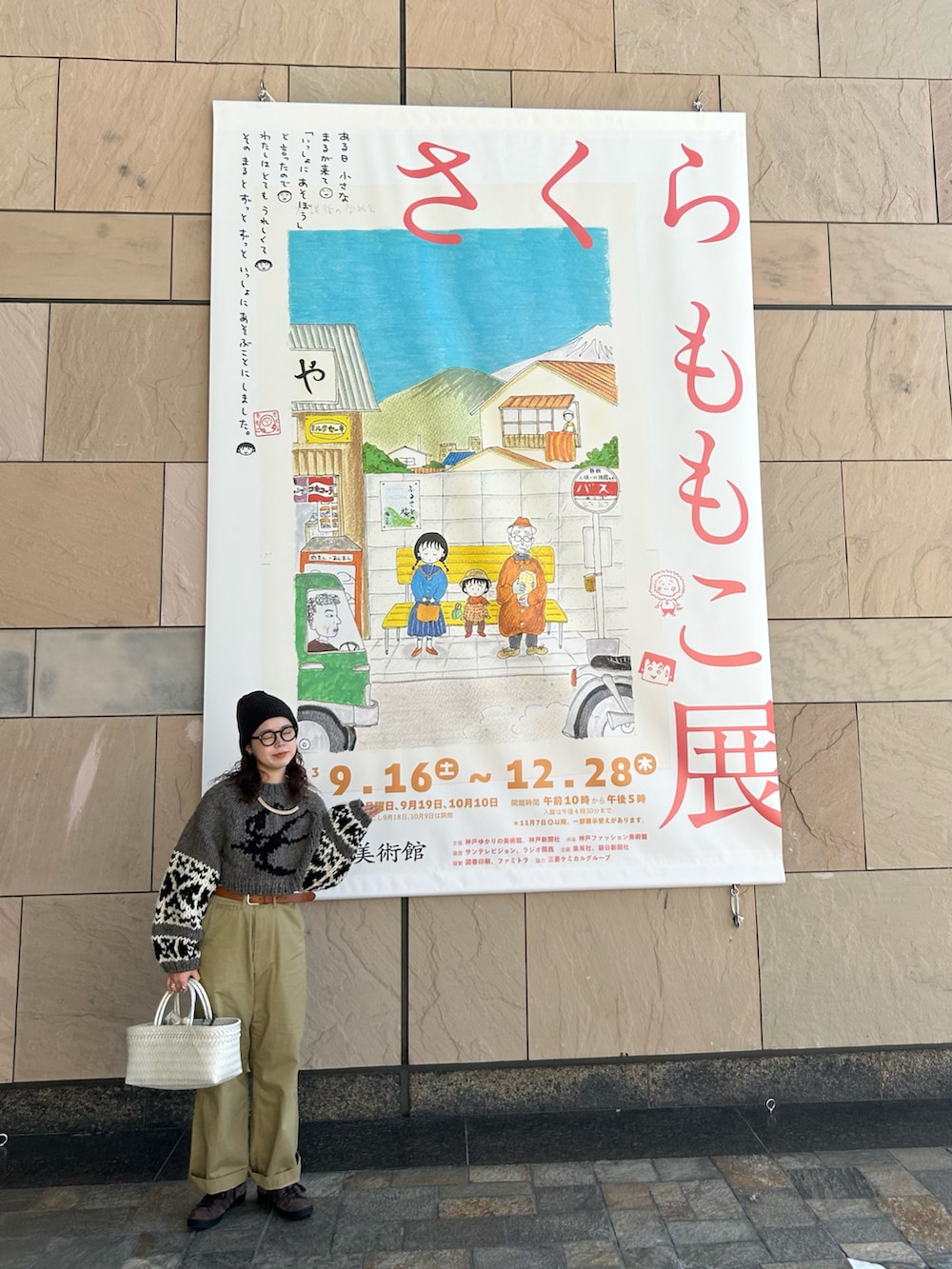 グレー系のニット/セーター、ブラウン系のスニーカー、ホワイト系のかごバッグを着用したレディースの秋コーディネートの2枚目の写真