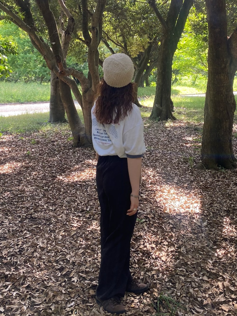 ブラック系のその他パンツ、ブラウン系のスニーカー、ホワイト系のTシャツ/カットソーを着用したレディースの夏コーディネートの2枚目の写真