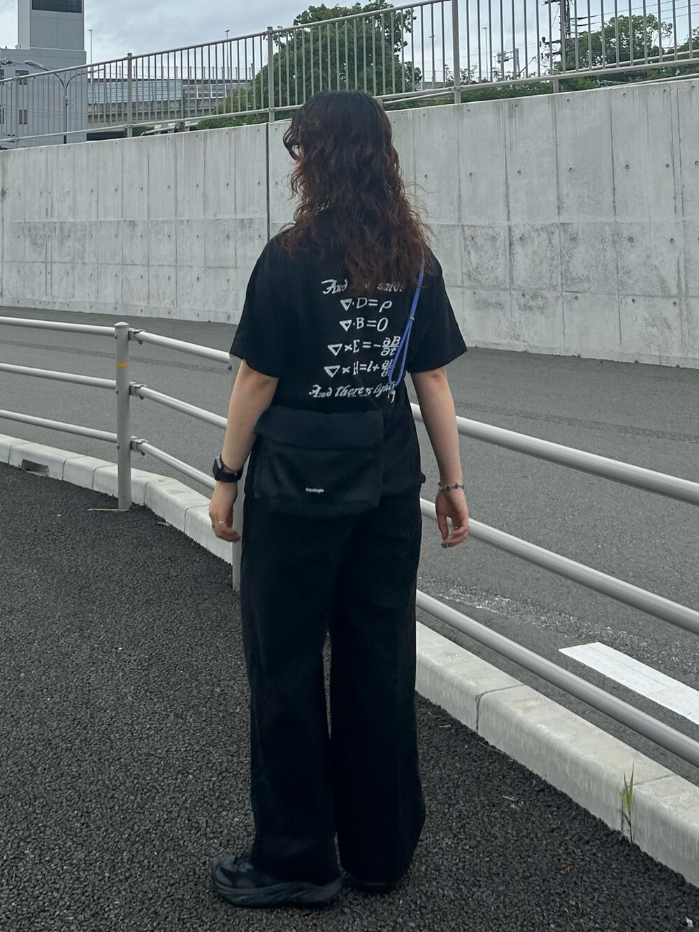 ブラック系のTシャツ/カットソー、ブラック系のスラックス、ブラック系のサンダルを着用したレディースの夏コーディネートの2枚目の写真