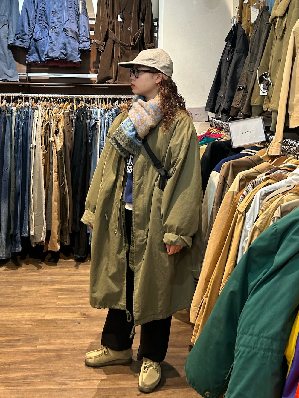 ブラック系のショルダーバッグ、グリーン系のモッズコート、ブラック系のその他パンツを着用したレディースの冬コーディネートの2枚目の写真