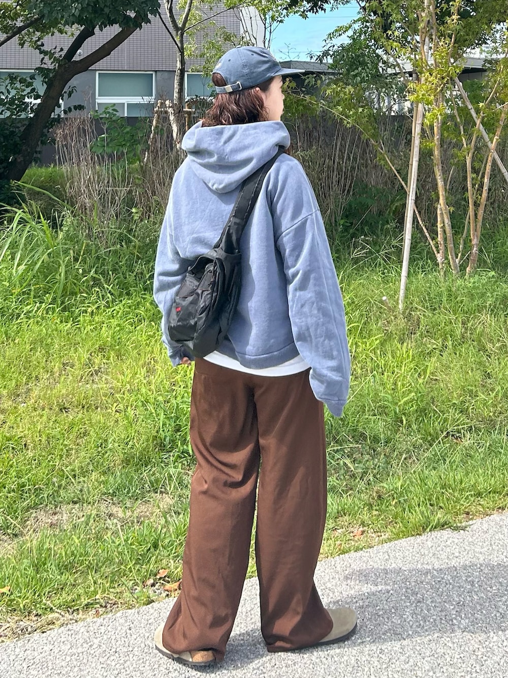 ブラウン系のその他パンツ、グレー系のサンダル、ブルー系のパーカーを着用したレディースの秋コーディネートの2枚目の写真