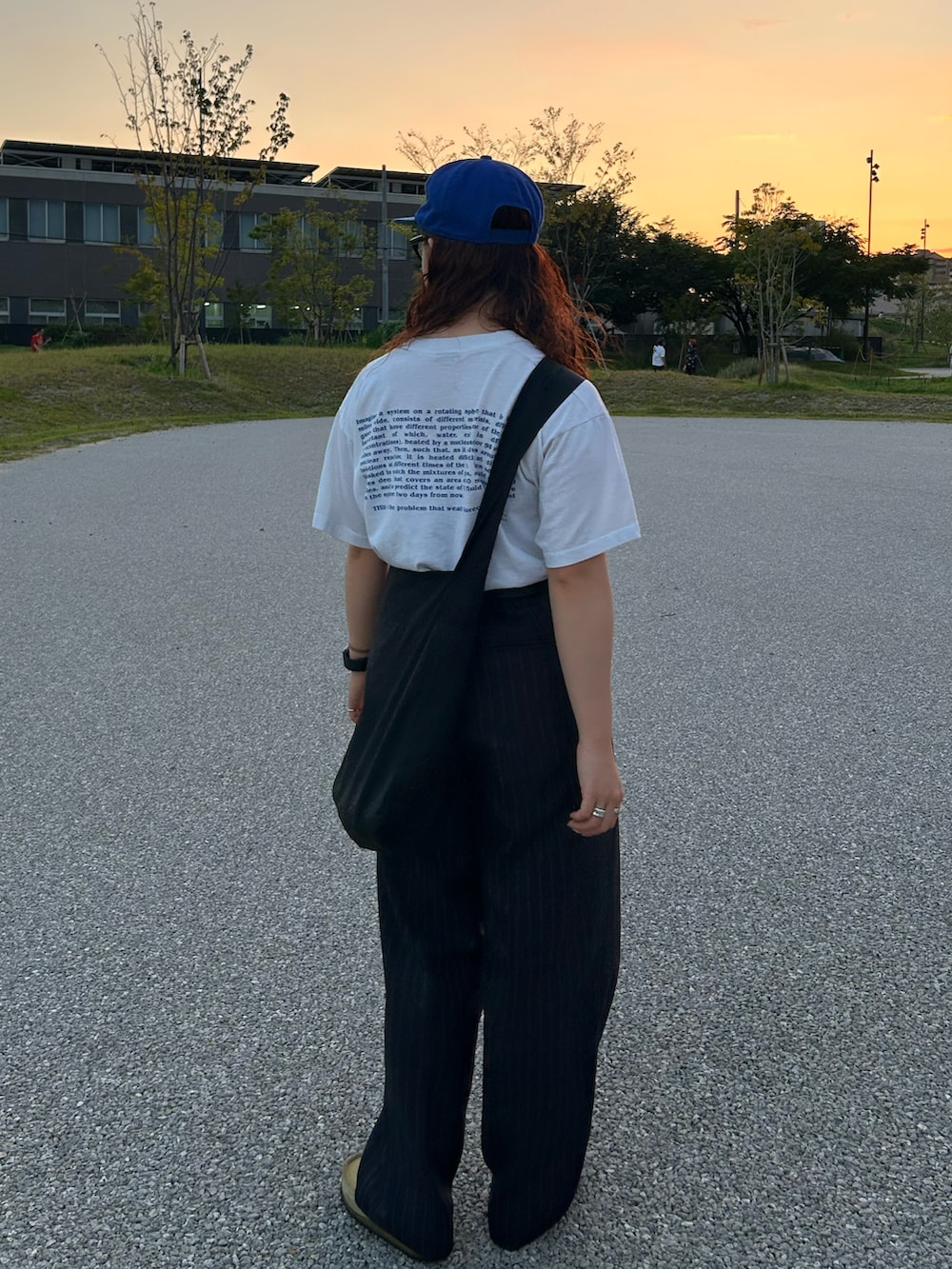 ホワイト系のTシャツ/カットソー、ブラック系のショルダーバッグ、ブルー系のスラックスを着用したレディースの秋コーディネートの2枚目の写真