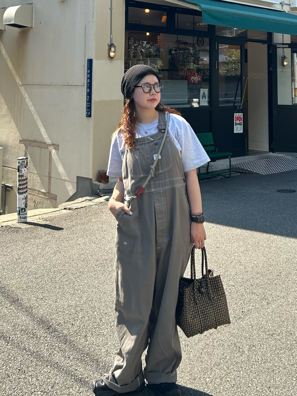 グレー系のサロペット/オーバーオール、ブラック系のかごバッグ、ブラック系のサンダルを着用したレディースの夏コーディネートの3枚目の写真