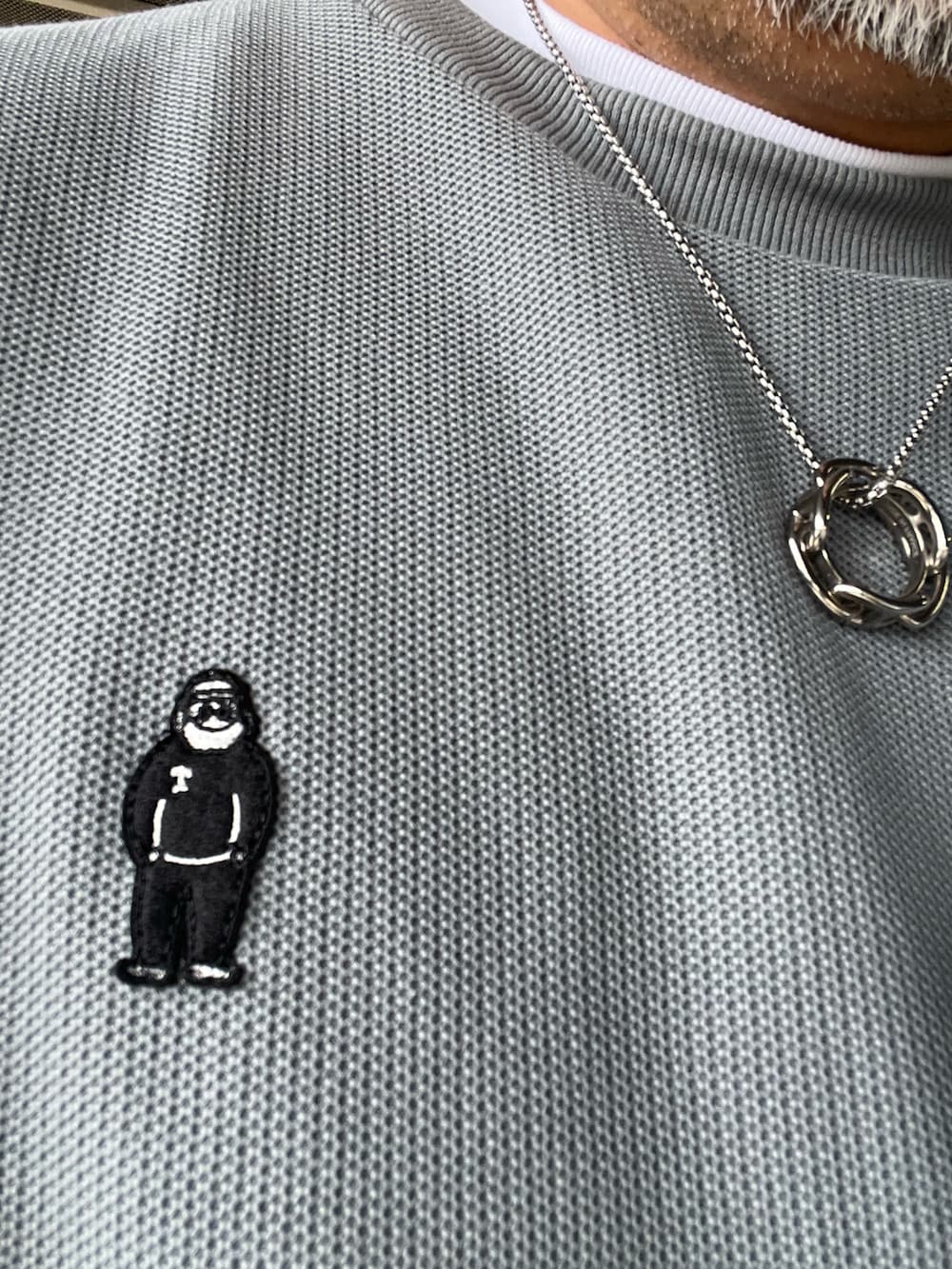 グレー系のTシャツ/カットソー、ブラック系のチノパンツ、ブラック系のスニーカーを着用したメンズの春コーディネートの2枚目の写真