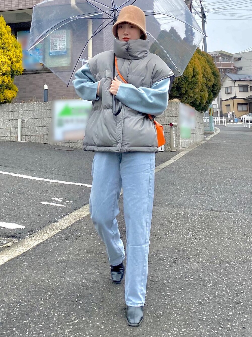 グレー系のダウンベスト、ブラック系のブーツ、ベージュ系のニットキャップ/ビーニーを着用したレディースの冬コーディネートの2枚目の写真