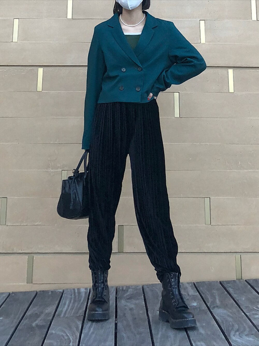 ブラック系のハンドバッグ、ブラック系のスラックス、ブラック系のブーツを着用したレディースの秋コーディネートの2枚目の写真