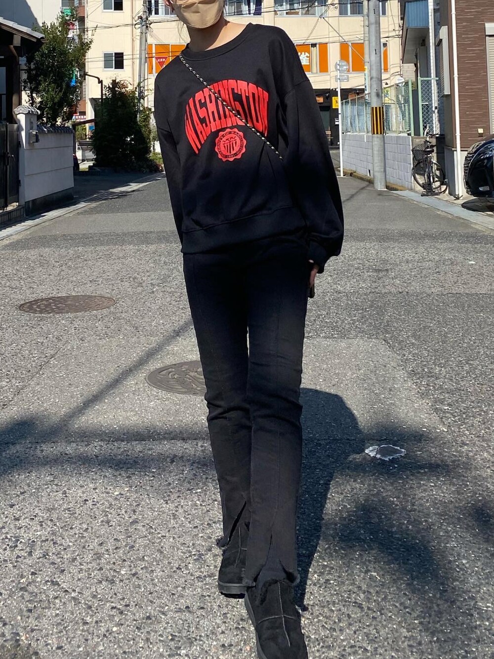 ブラック系のデニムパンツ、ブラック系のブーツ、ブラック系のスウェットを着用したレディースの秋コーディネートの2枚目の写真