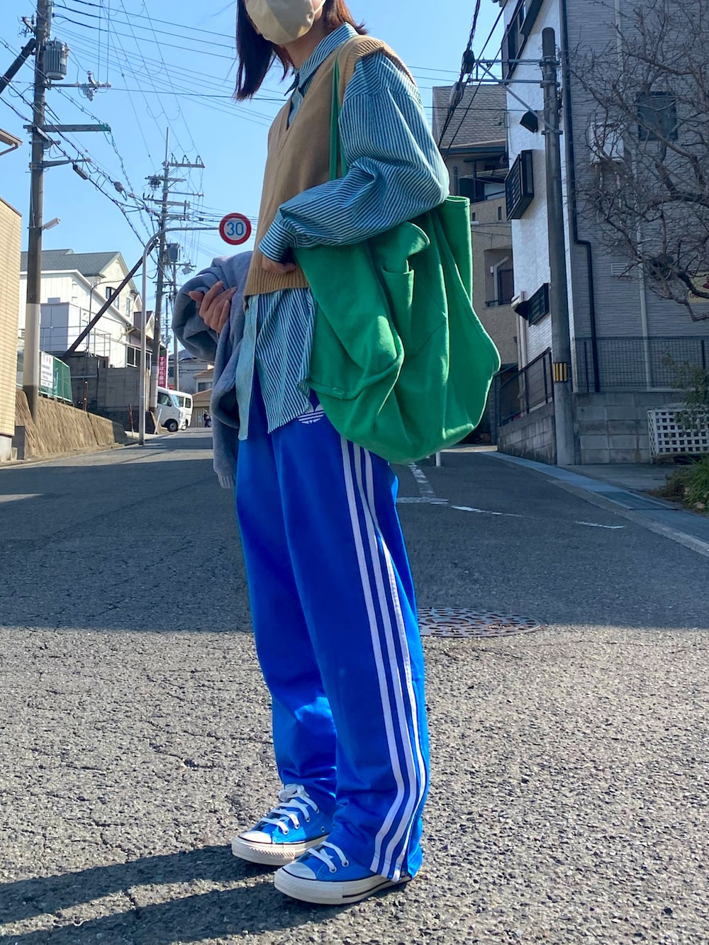 ブルー系のその他パンツ、ブルー系のスニーカー、ベージュ系のベストを着用したレディースの春コーディネートの2枚目の写真