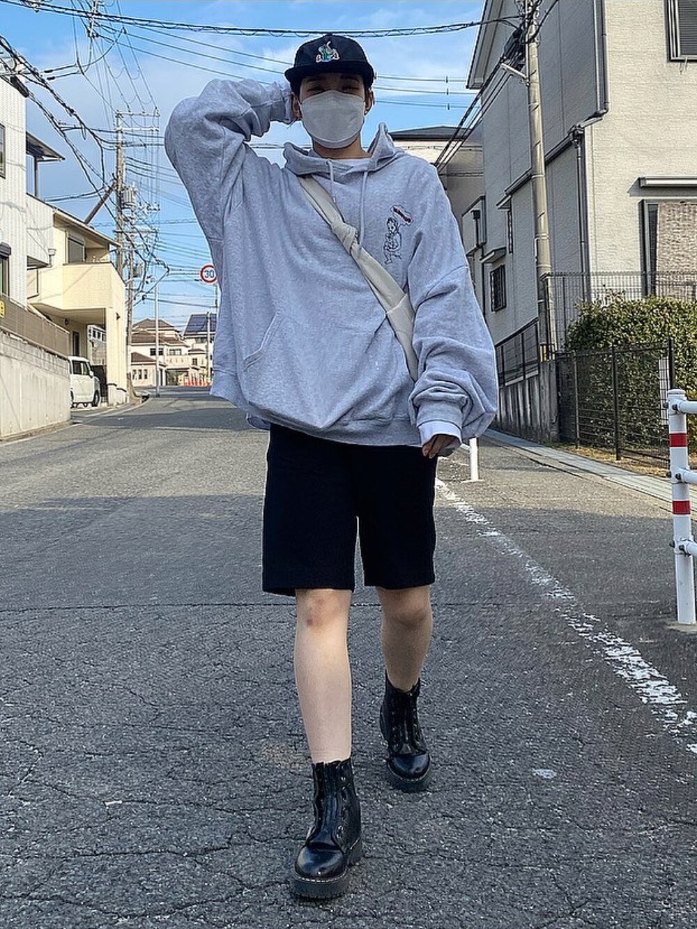 グレー系のパーカー、ブラック系のパンツ、ブラック系のブーツを着用したレディースの冬コーディネートの2枚目の写真