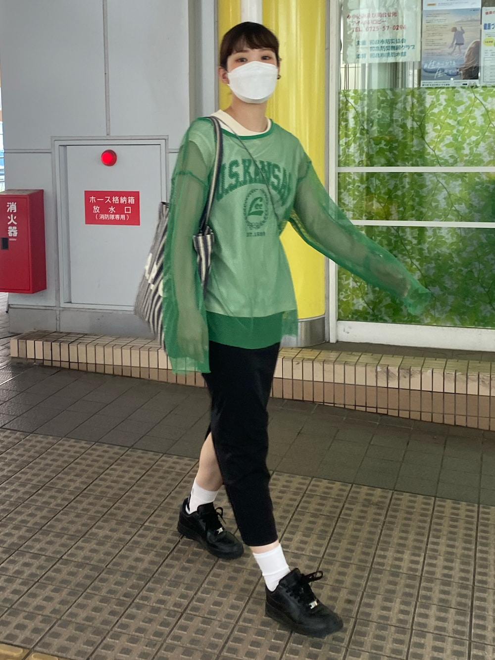 ブルー系のトートバッグ、ブラック系のスカート、ブラック系のスニーカーを着用したレディースの夏コーディネートの2枚目の写真