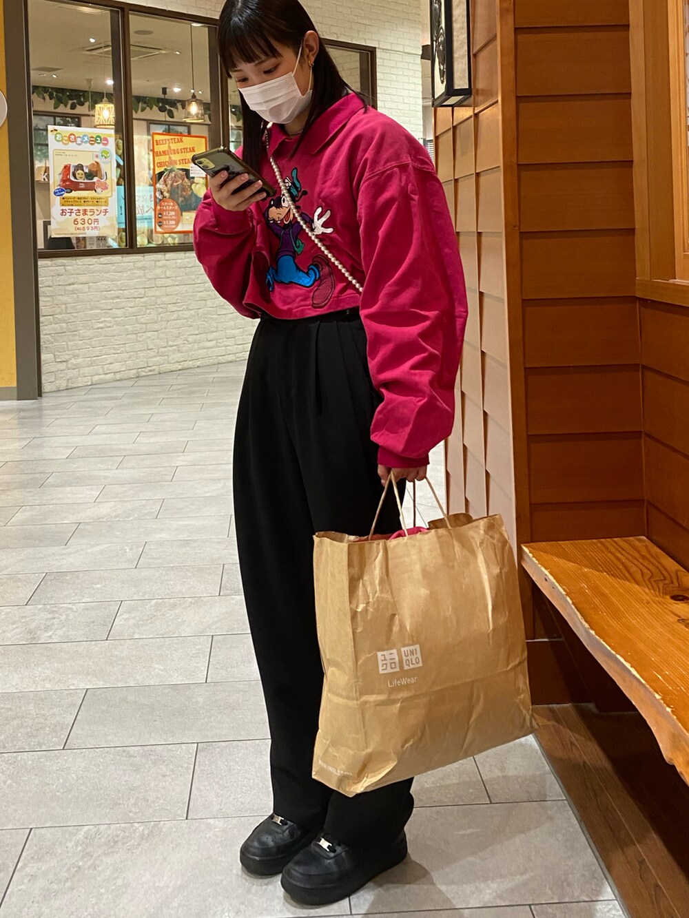 ブラック系のスラックス、ブラック系のスニーカー、ブラック系のショルダーバッグを着用したレディースの冬コーディネートの2枚目の写真