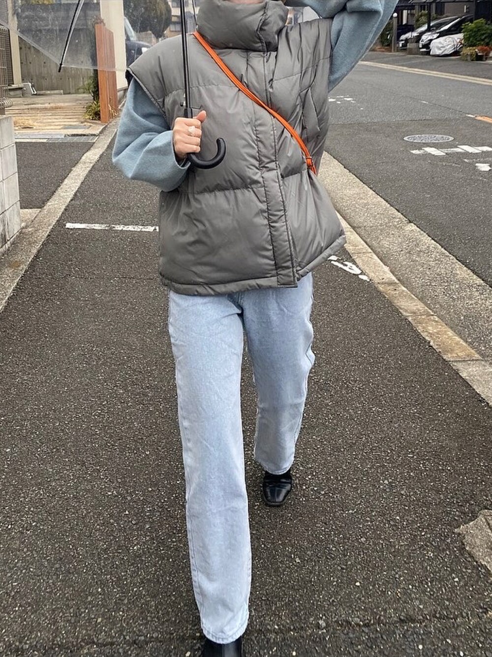 グレー系のダウンベスト、ブラック系のブーツ、ベージュ系のニットキャップ/ビーニーを着用したレディースの冬コーディネートの3枚目の写真