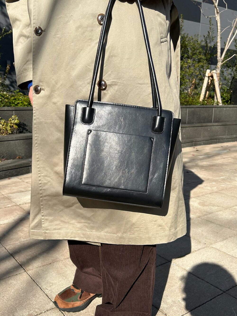 グリーン系のニット/セーター、ベージュ系のトレンチコート、ブラウン系のその他パンツを着用したメンズの冬コーディネートの3枚目の写真