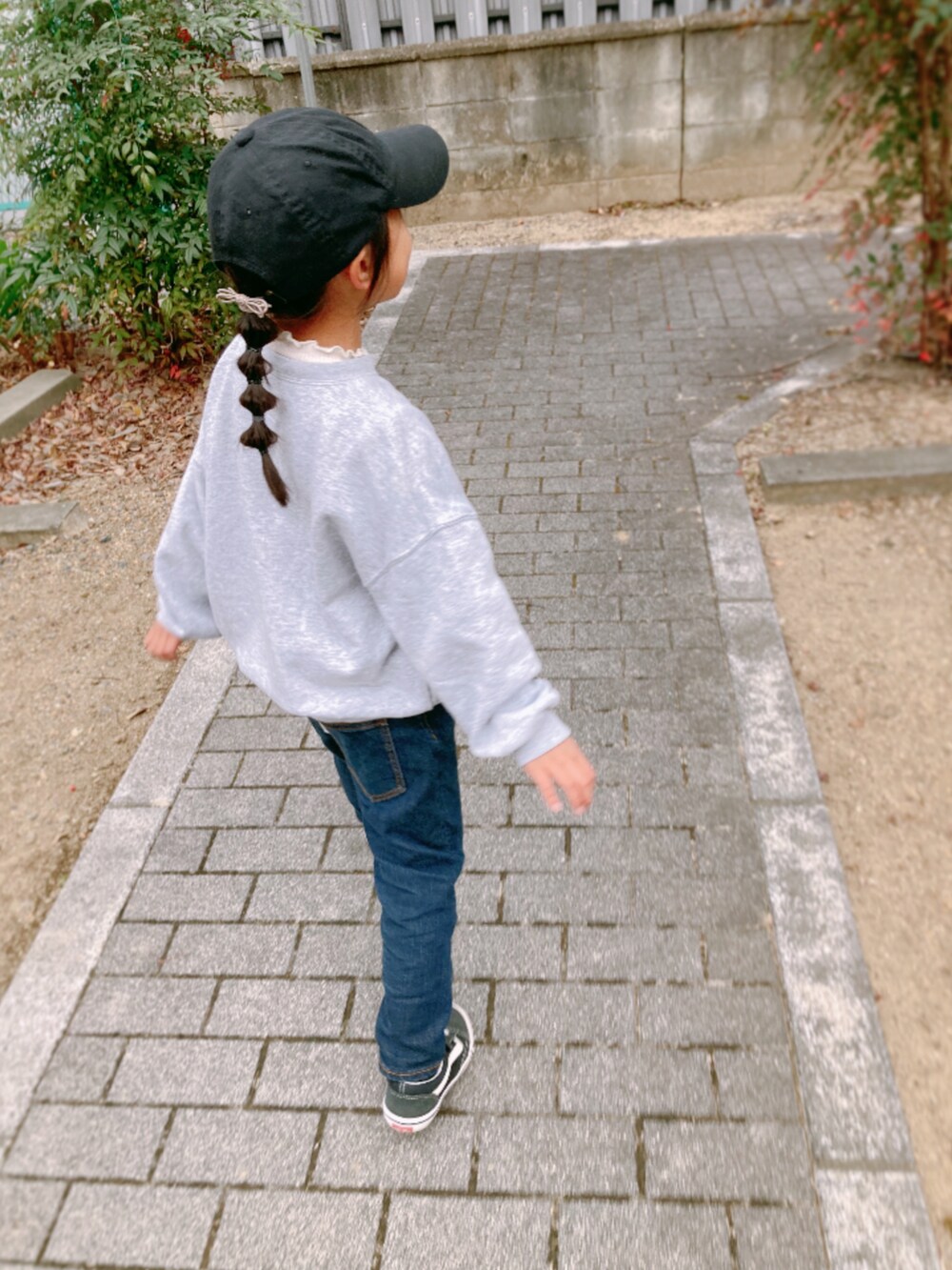 グレー系のスウェット、ブルー系のデニムパンツ、ブラック系のスニーカーを着用したキッズの冬コーディネートの2枚目の写真