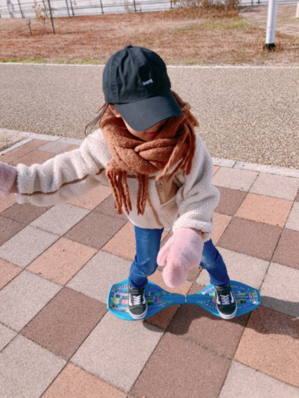 ホワイト系のその他アウター、ブルー系のデニムパンツ、ブラック系のスニーカーを着用したキッズの冬コーディネートの2枚目の写真