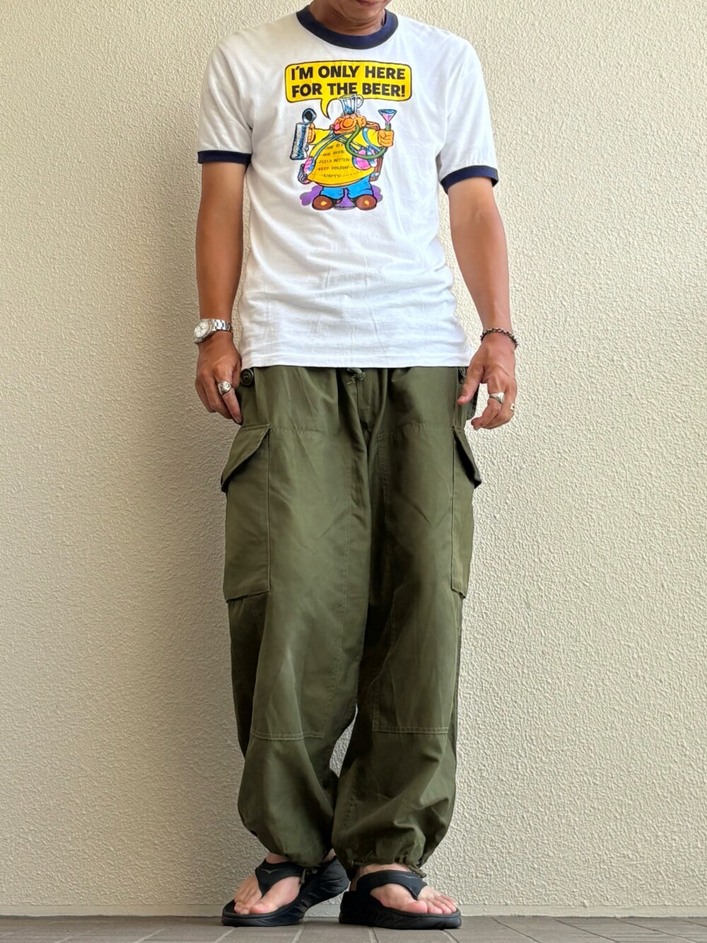グリーン系のカーゴパンツ、ブラック系のサンダルを着用したメンズの夏コーディネートの2枚目の写真