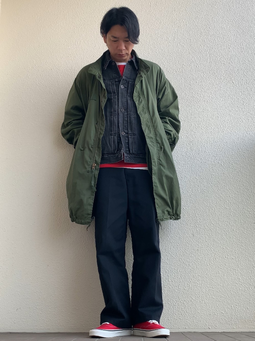 ブラック系のデニムジャケット、ブラック系のチノパンツ、レッド系のスニーカーを着用したメンズの冬コーディネートの2枚目の写真