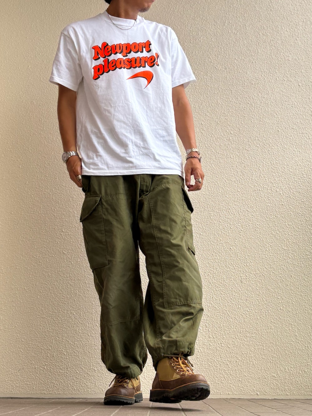 グリーン系のカーゴパンツ、グリーン系のブーツ、ブラウン系のメガネを着用したメンズの夏コーディネートの2枚目の写真