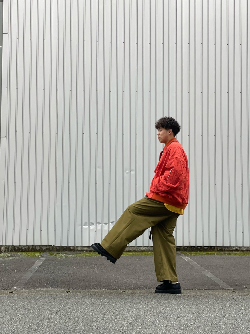 オレンジ系のブルゾン、オレンジ系のニット/セーター、イエロー系のシャツ/ブラウスを着用したメンズの秋コーディネートの3枚目の写真