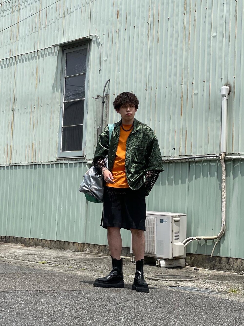グリーン系のシャツ/ブラウス、オレンジ系のTシャツ/カットソー、ブラック系のTシャツ/カットソーを着用したメンズの秋コーディネートの2枚目の写真