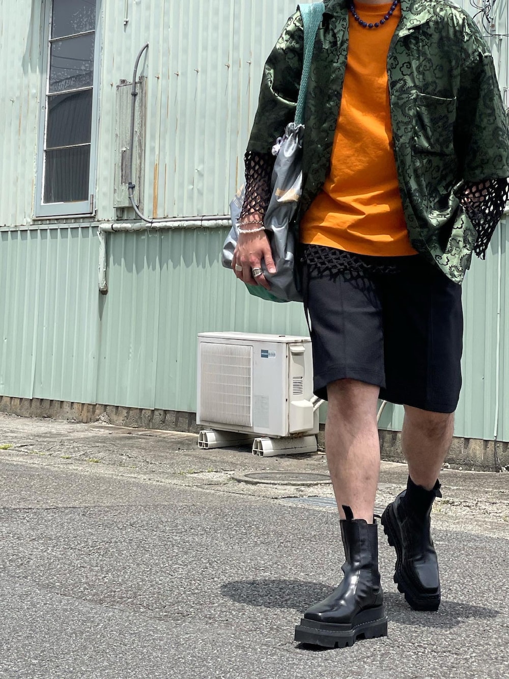 グリーン系のシャツ/ブラウス、オレンジ系のTシャツ/カットソー、ブラック系のTシャツ/カットソーを着用したメンズの秋コーディネートの3枚目の写真