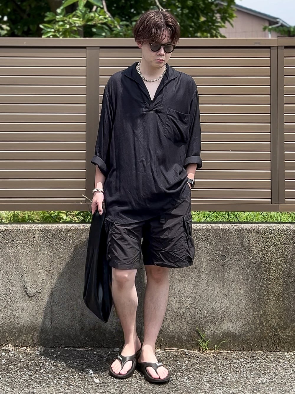 ブラック系のシャツ/ブラウス、ブラック系のカーゴパンツ、ブラック系のサンダルを着用したメンズの夏コーディネートの3枚目の写真