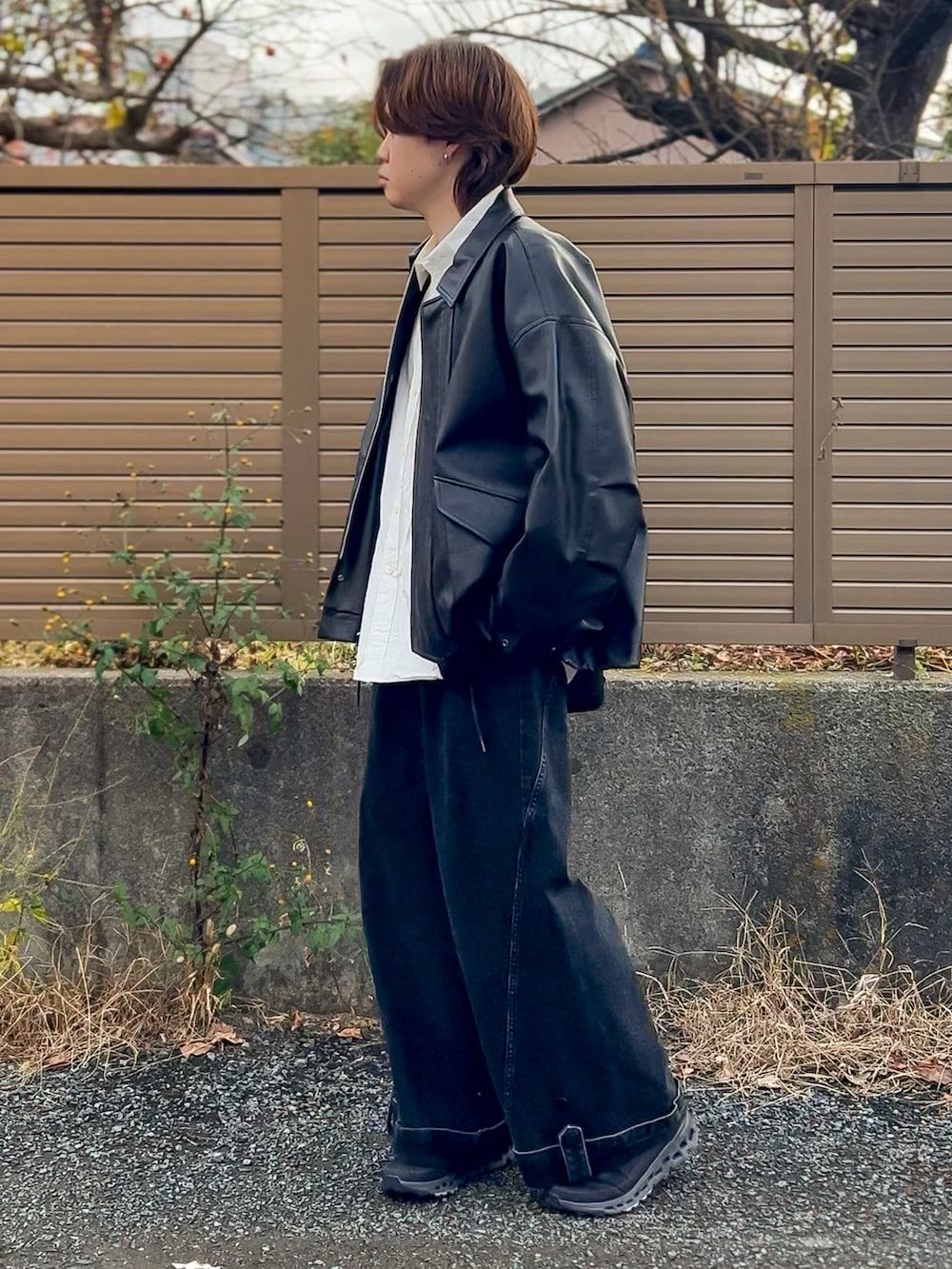 ブラウン系のブルゾン、ブラック系のスニーカー、ホワイト系のシャツ/ブラウスを着用したメンズの秋コーディネートの3枚目の写真