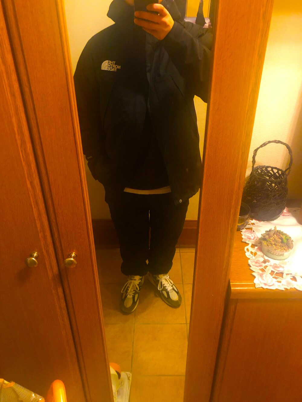 ブラック系のトップス、グリーン系のスニーカーを着用したメンズの冬コーディネートの2枚目の写真