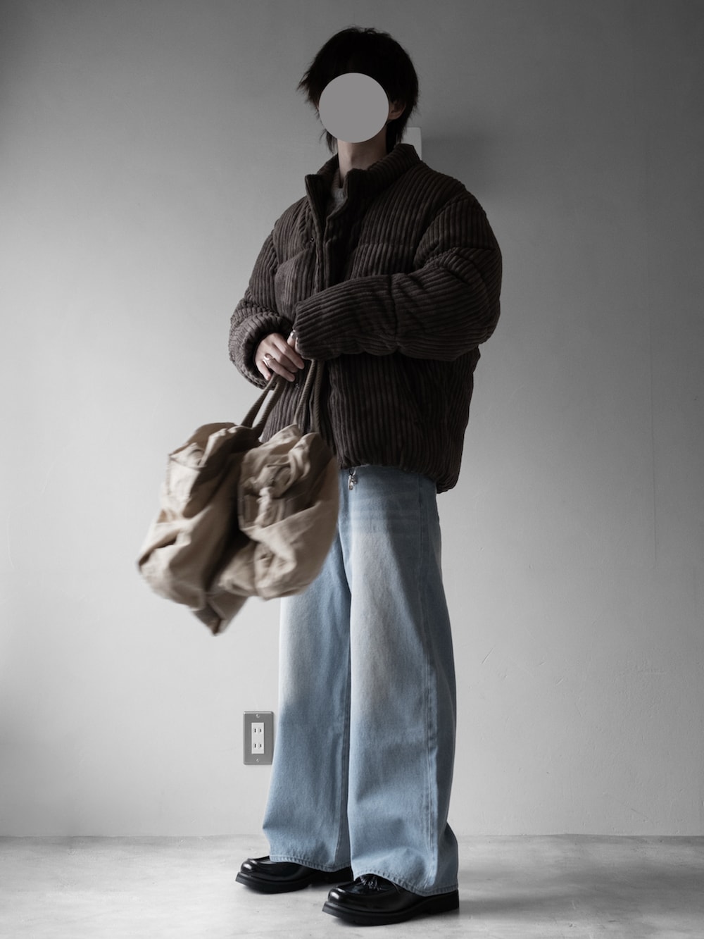 グレー系のニット/セーター、ブラウン系のダウンジャケット/コート、グリーン系のショルダーバッグを着用したメンズの秋コーディネートの4枚目の写真