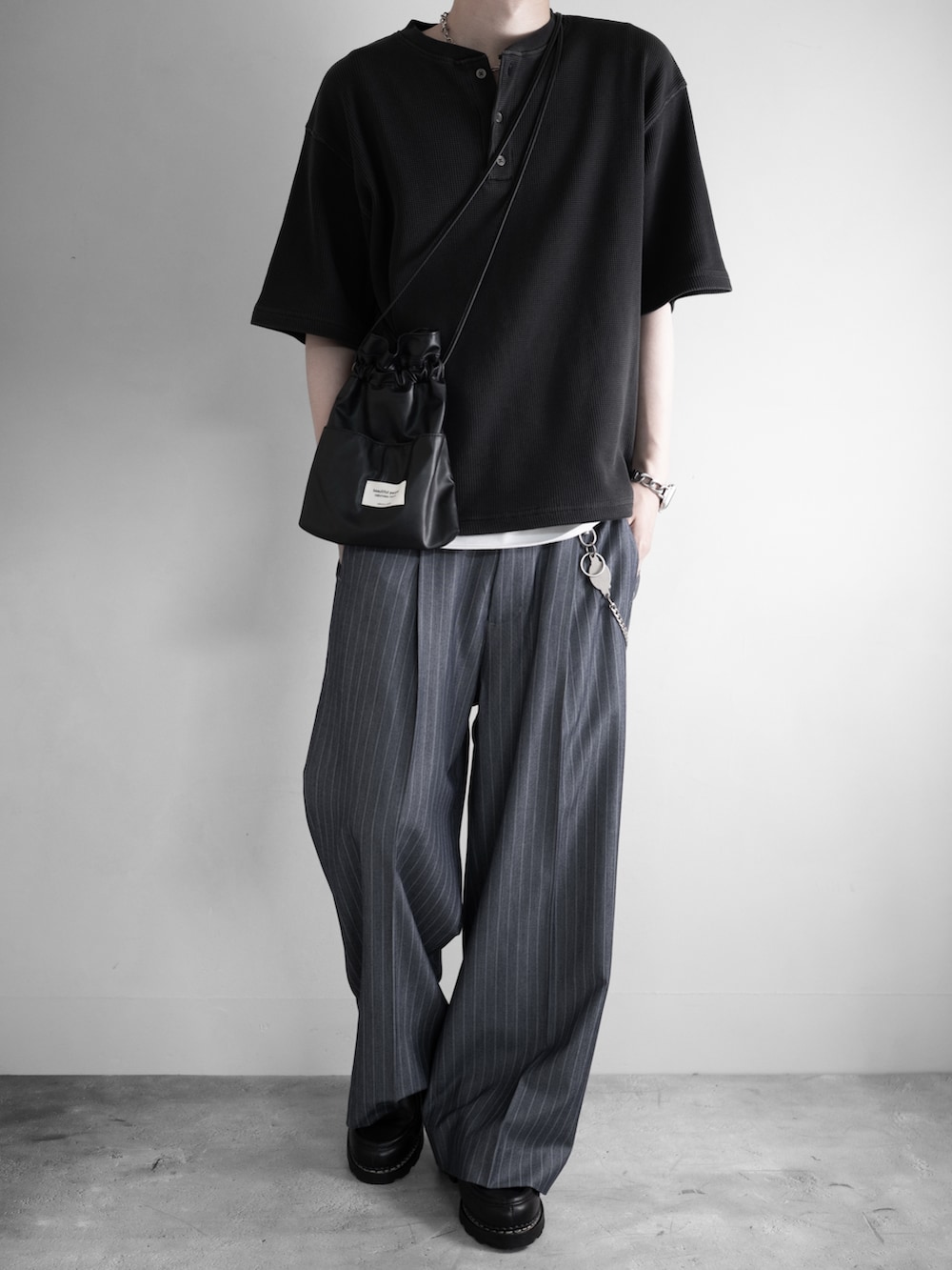 グレー系のTシャツ/カットソー、ホワイト系のタンクトップ、ブラック系のスラックスを着用したメンズの夏コーディネートの2枚目の写真