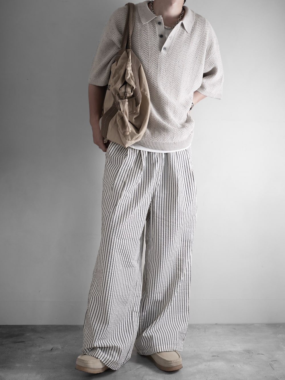 ホワイト系のその他パンツ、ベージュ系のモカシン/デッキシューズ、ホワイト系のタンクトップを着用したメンズの夏コーディネートの2枚目の写真
