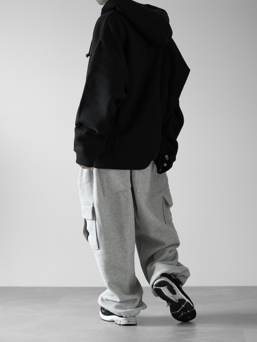 ブラック系のパーカー、グレー系のスウェットパンツ、ブラック系のスニーカーを着用したメンズの秋コーディネートの2枚目の写真