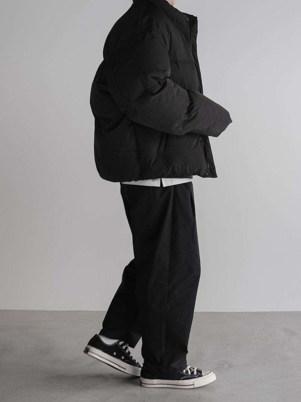 ブラック系のダウンジャケット/コート、ブラック系のニット/セーター、ブラック系のその他パンツを着用したメンズの冬コーディネートの2枚目の写真