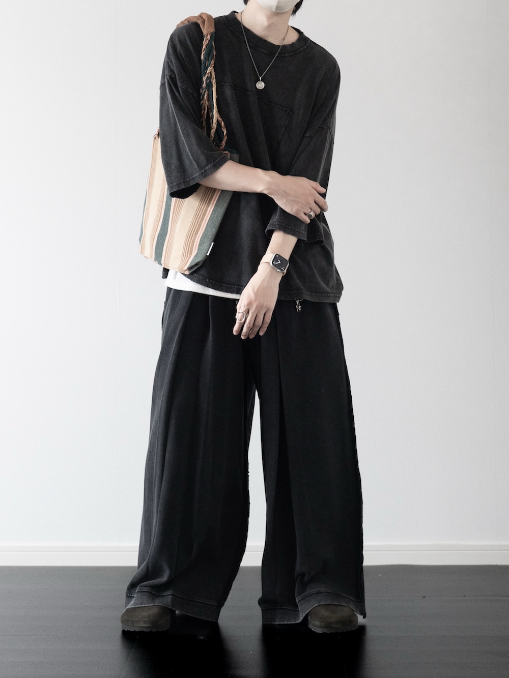 グレー系のTシャツ/カットソー、ホワイト系のタンクトップ、グリーン系のトートバッグを着用したメンズの夏コーディネートの3枚目の写真