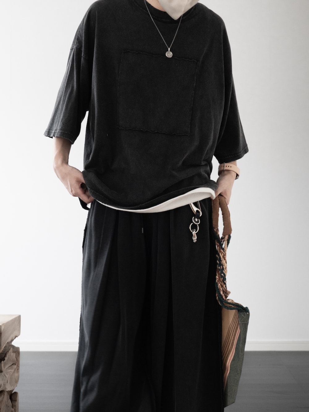 グレー系のTシャツ/カットソー、ホワイト系のタンクトップ、グリーン系のトートバッグを着用したメンズの夏コーディネートの4枚目の写真