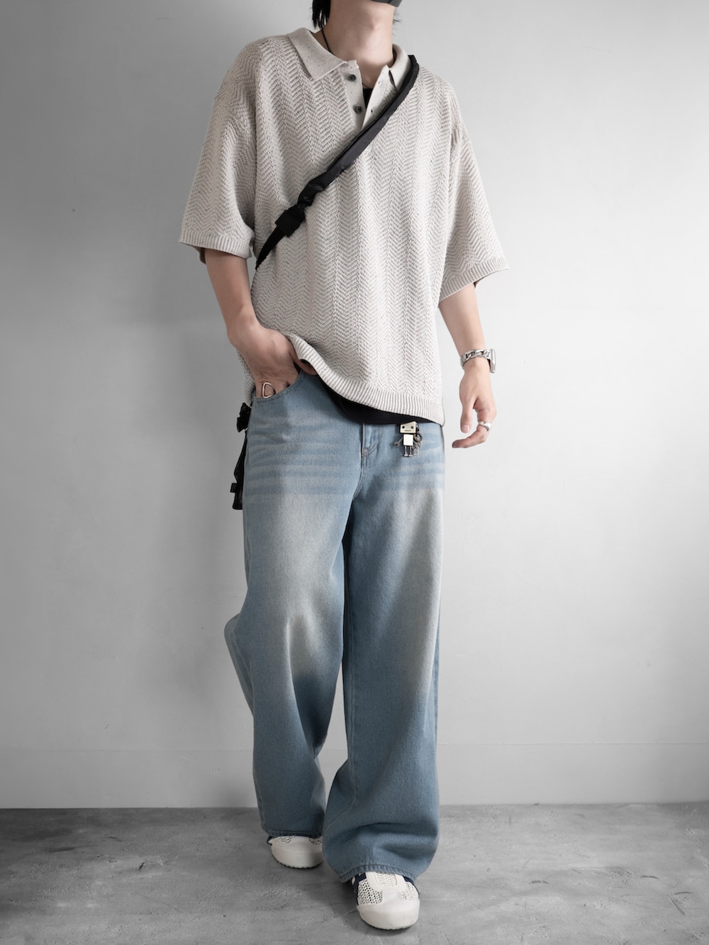 ブラック系のタンクトップ、ブルー系のデニムパンツ、ホワイト系のサンダルを着用したメンズの夏コーディネートの2枚目の写真