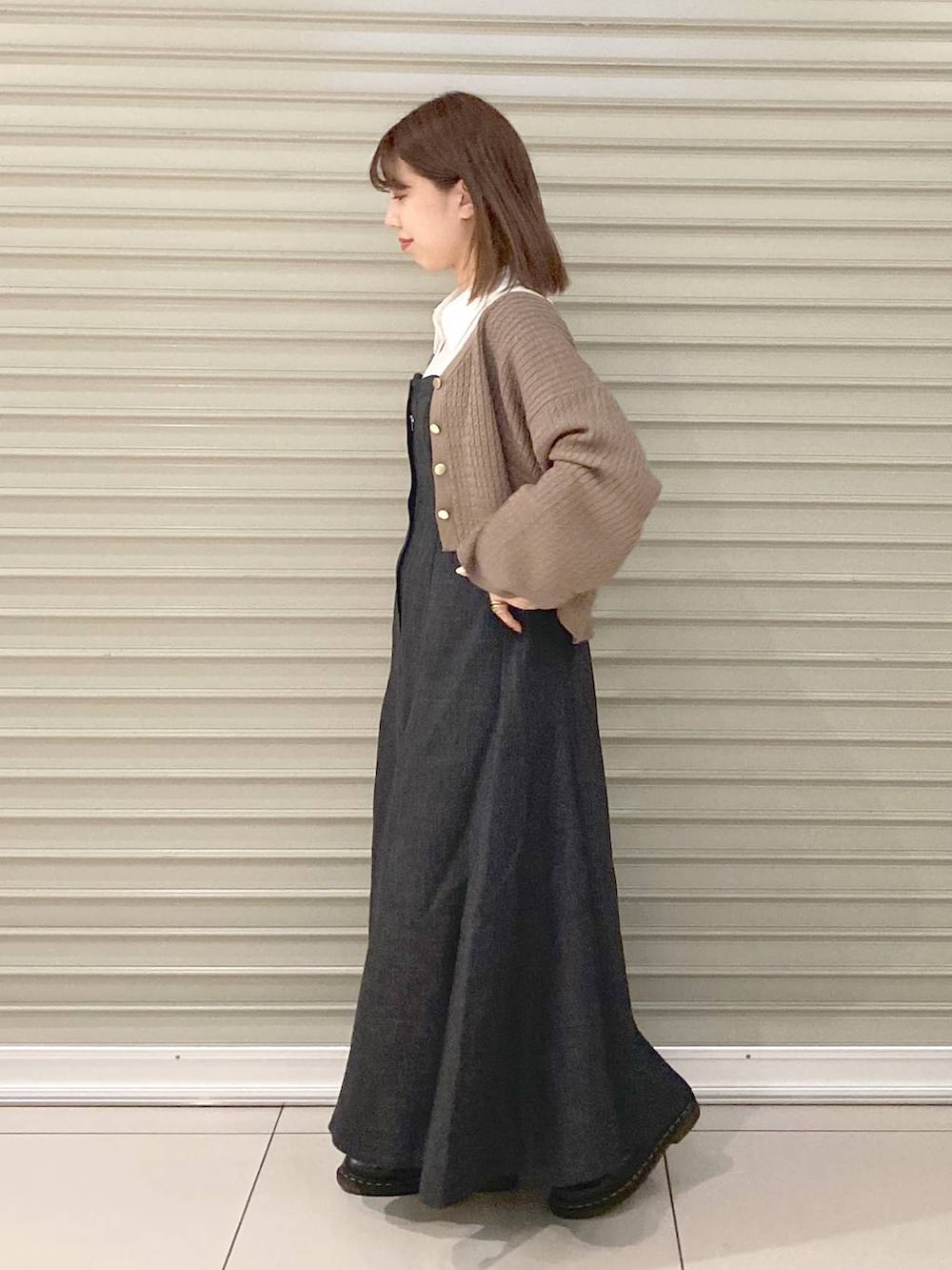 ホワイト系のハンドバッグ、ブラウン系のカーディガン/ボレロ、グレー系のワンピースを着用したレディースの秋コーディネートの3枚目の写真