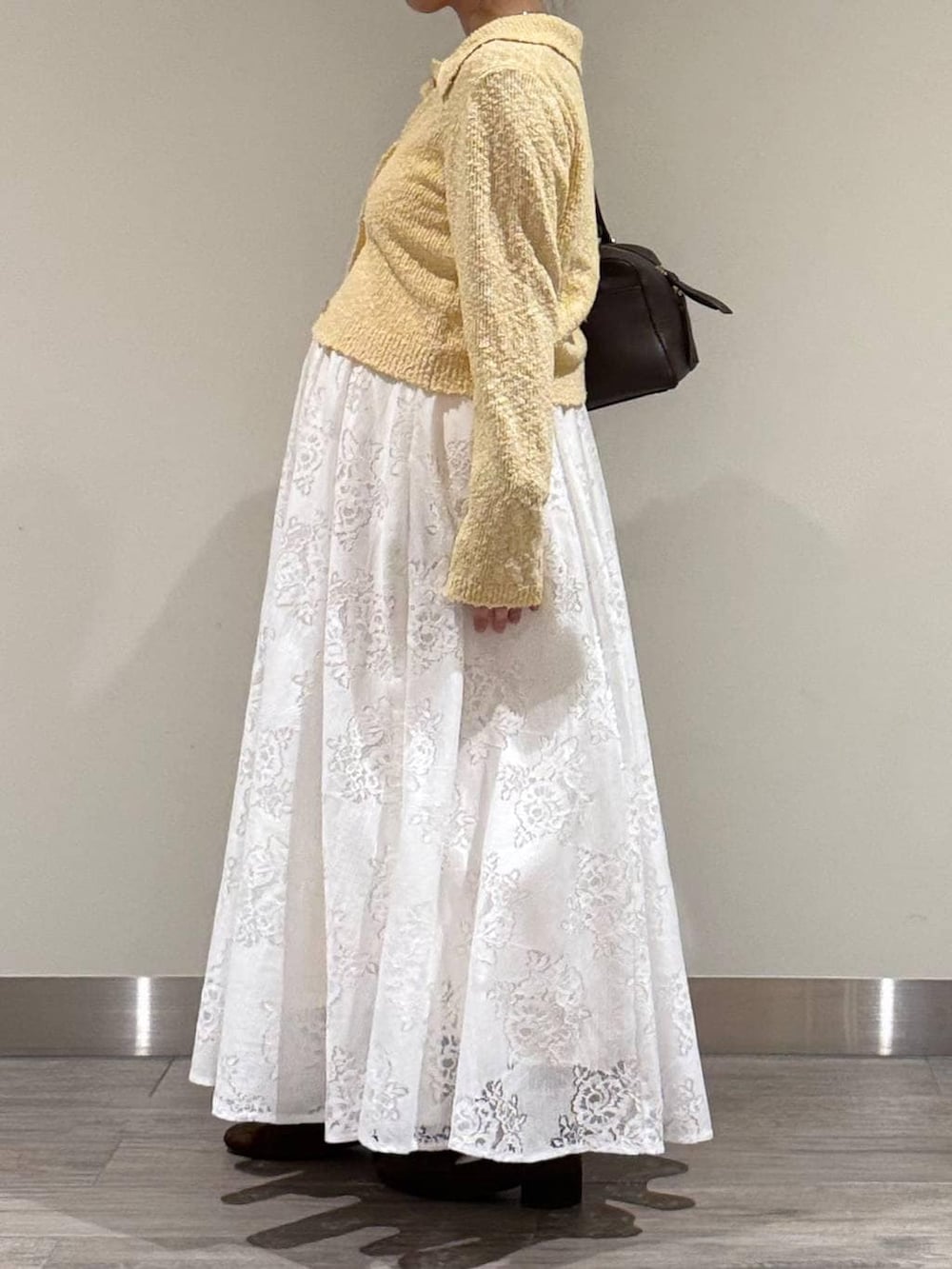 ブラウン系のハンドバッグ、ブラウン系のローファー、ホワイト系のワンピースを着用したレディースの春コーディネートの4枚目の写真