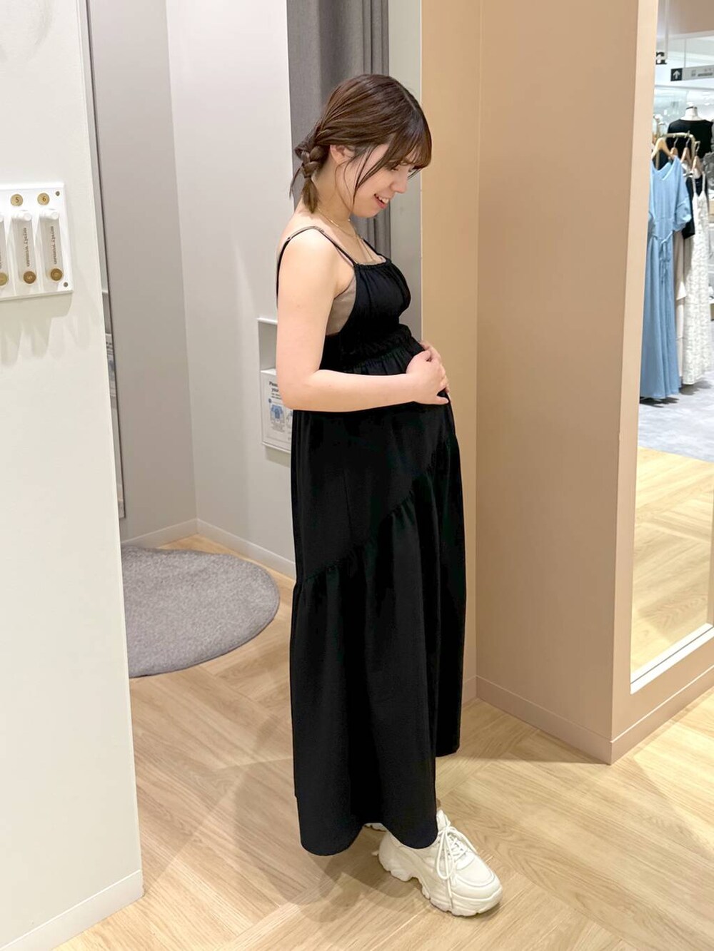 ブラック系のワンピース、ホワイト系のスニーカーを着用したレディースの夏コーディネートの3枚目の写真