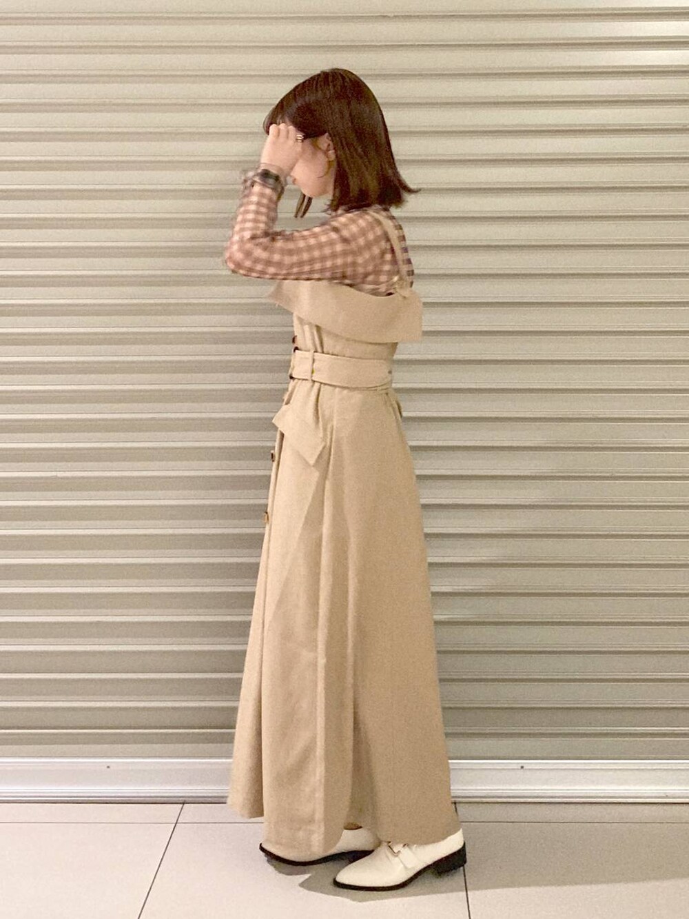 ブラック系のボストンバッグ、ホワイト系のその他シューズ、ベージュ系のジャンパースカートを着用したレディースの夏コーディネートの3枚目の写真