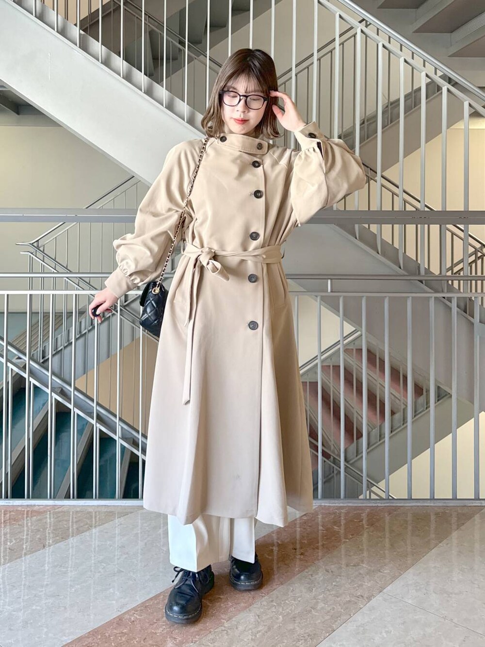 グレー系のニット/セーター、ブラック系のショルダーバッグ、ホワイト系のその他パンツを着用したレディースの春コーディネートの2枚目の写真