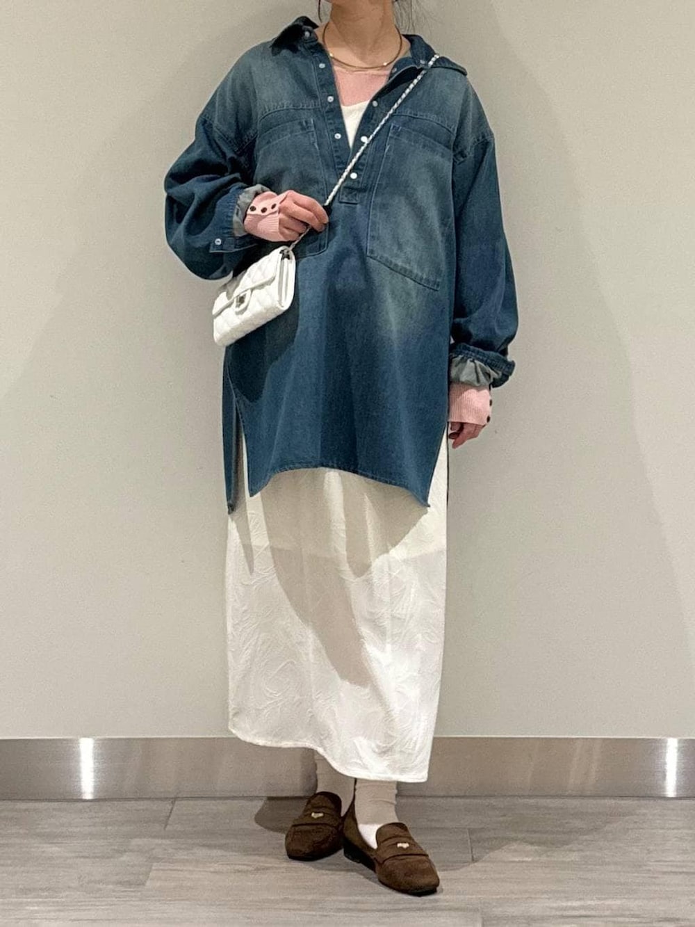 ブラウン系のローファー、ピンク系のニット/セーター、ホワイト系のワンピースを着用したレディースの春コーディネートの2枚目の写真