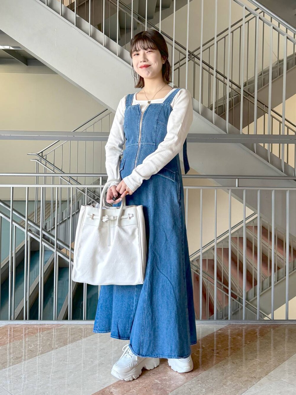 ホワイト系のトートバッグ、ホワイト系のTシャツ/カットソー、ホワイト系のスニーカーを着用したレディースの冬コーディネートの9枚目の写真