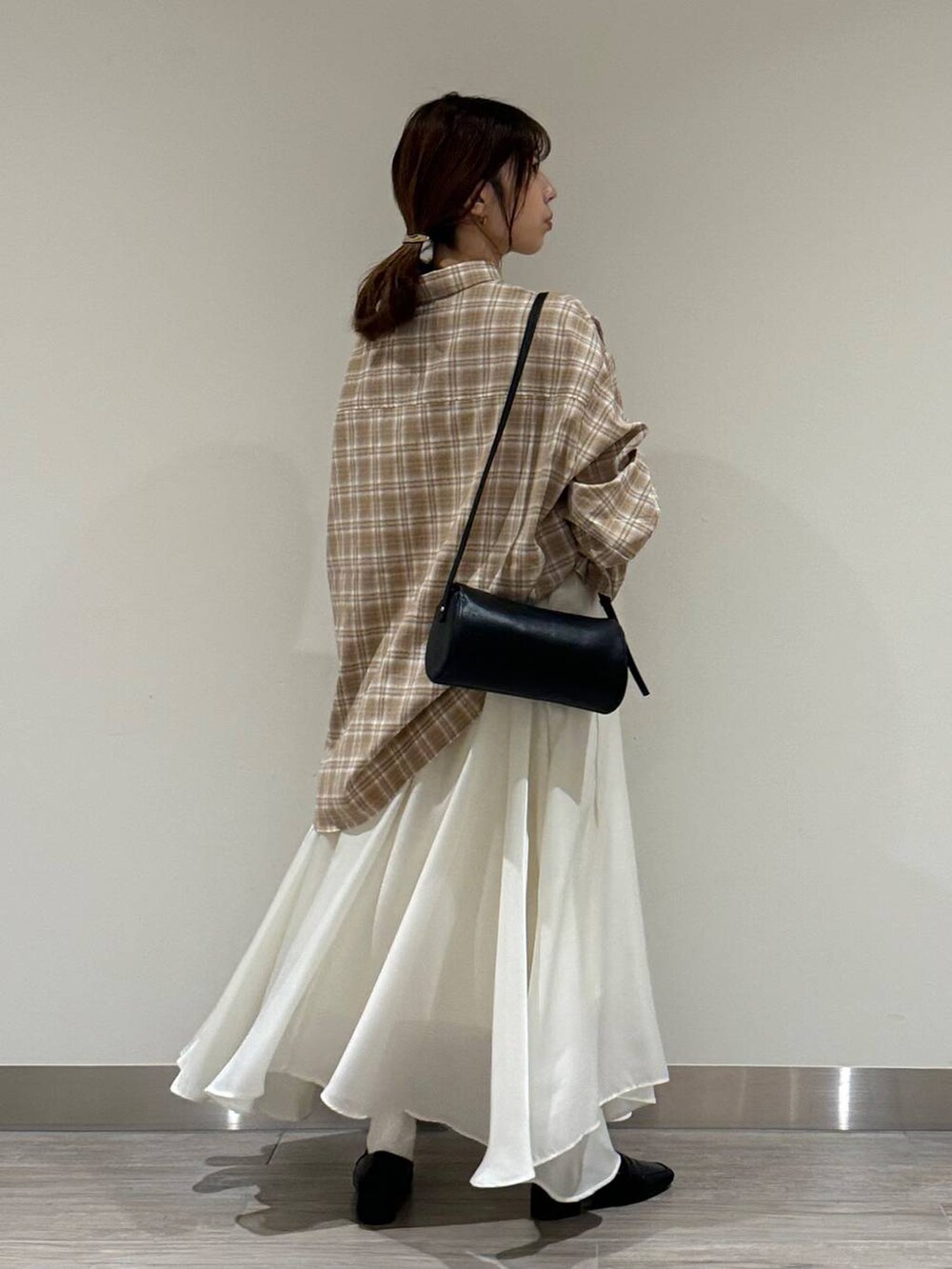 ベージュ系のシャツ/ブラウス、ブラック系のショルダーバッグ、ホワイト系のスカートを着用したレディースの秋コーディネートの3枚目の写真